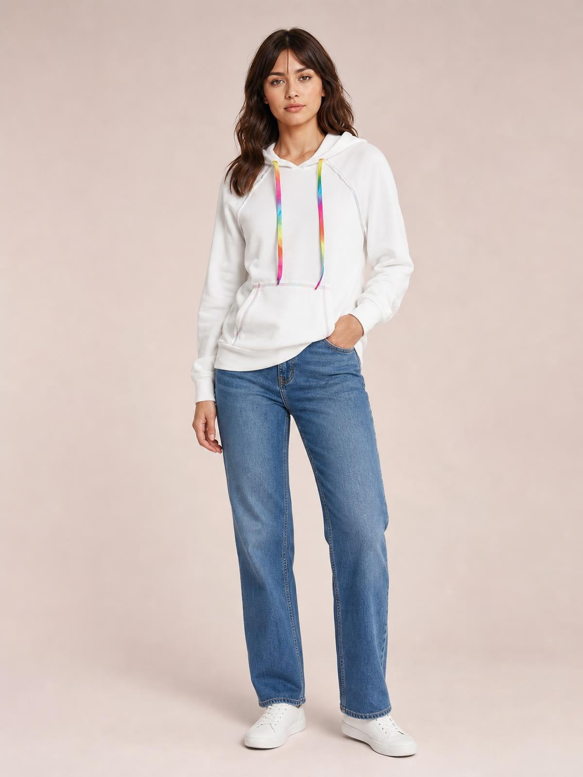 Model stands in a white drawstring hoodie with colorful cords, contrast stitching, raglan sleeves, a kangaroo pocket, and a relaxed silhouette.