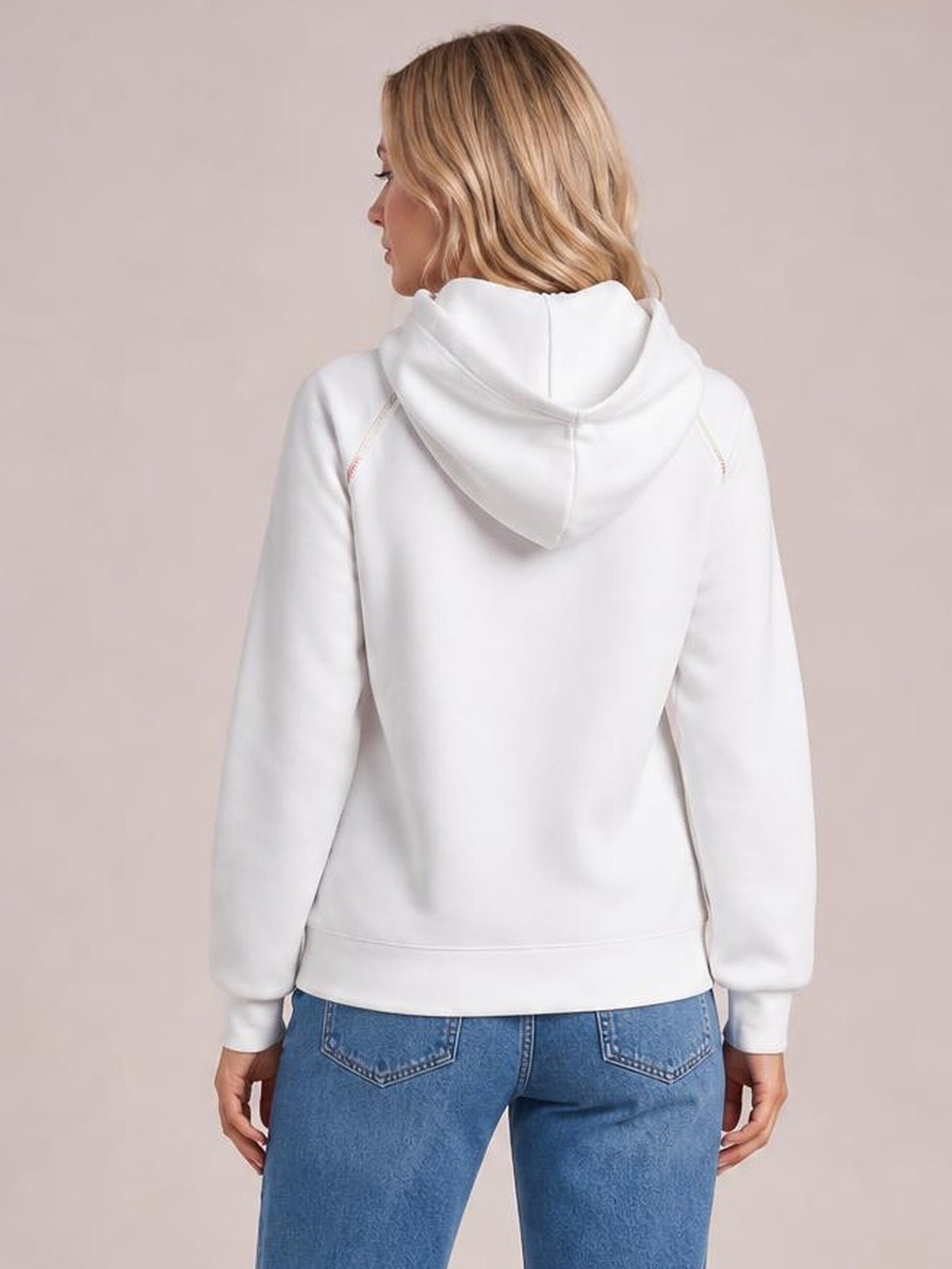 A model shows the back of a white hoodie with a drawstring hood, raglan sleeves, contrast stitching, ribbed cuffs, and a relaxed silhouette.