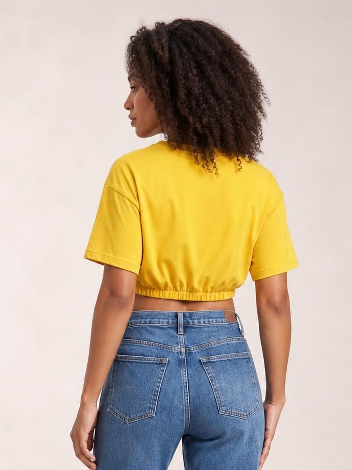 Model shown from the back wears a bright yellow drawstring round neck short sleeve T-shirt with a cropped, slightly relaxed silhouette and gathered hem.