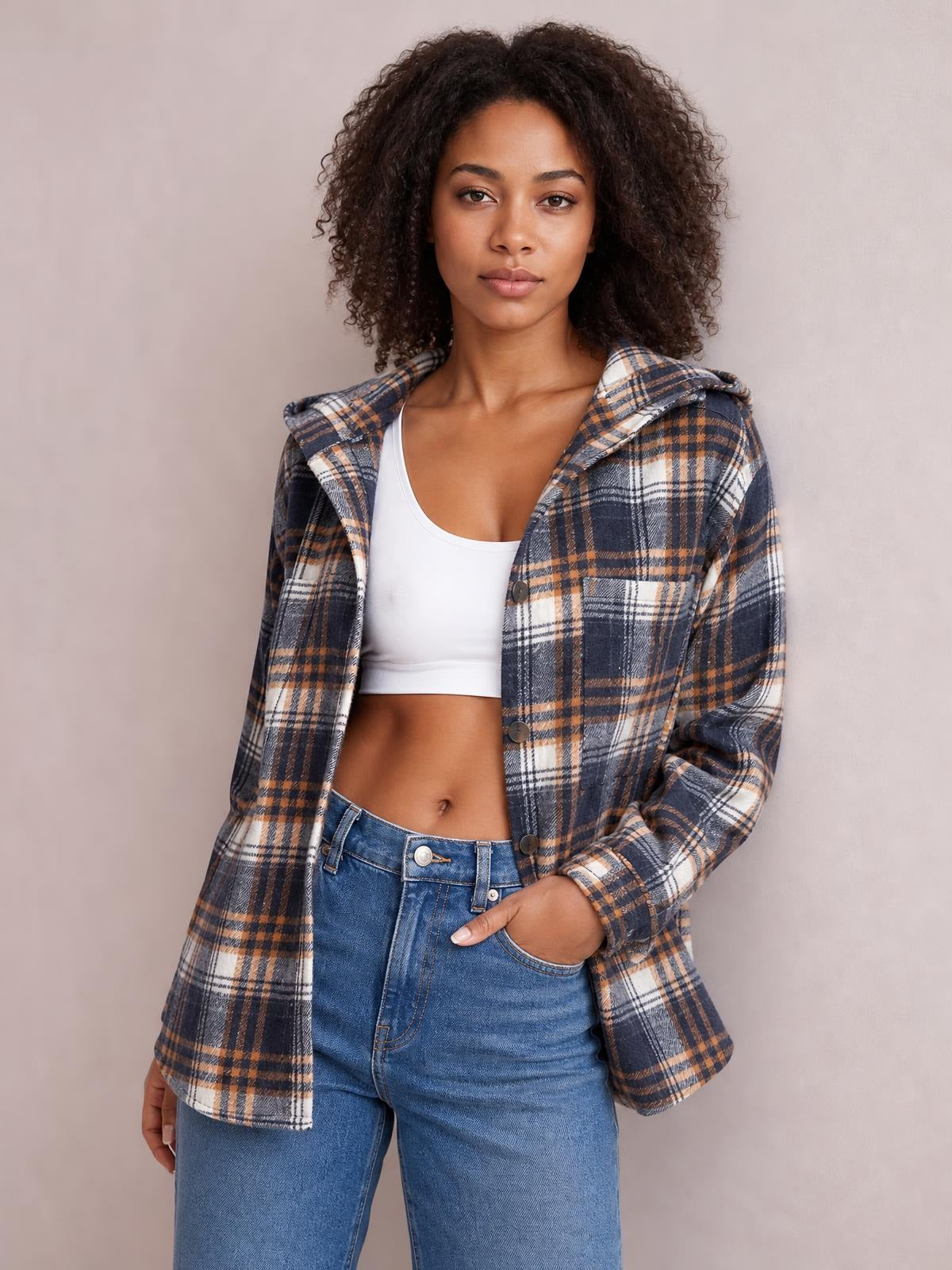 Model wears a navy, tan, and white plaid button-up hooded jacket with long sleeves, visible buttons and pockets, and a relaxed silhouette.