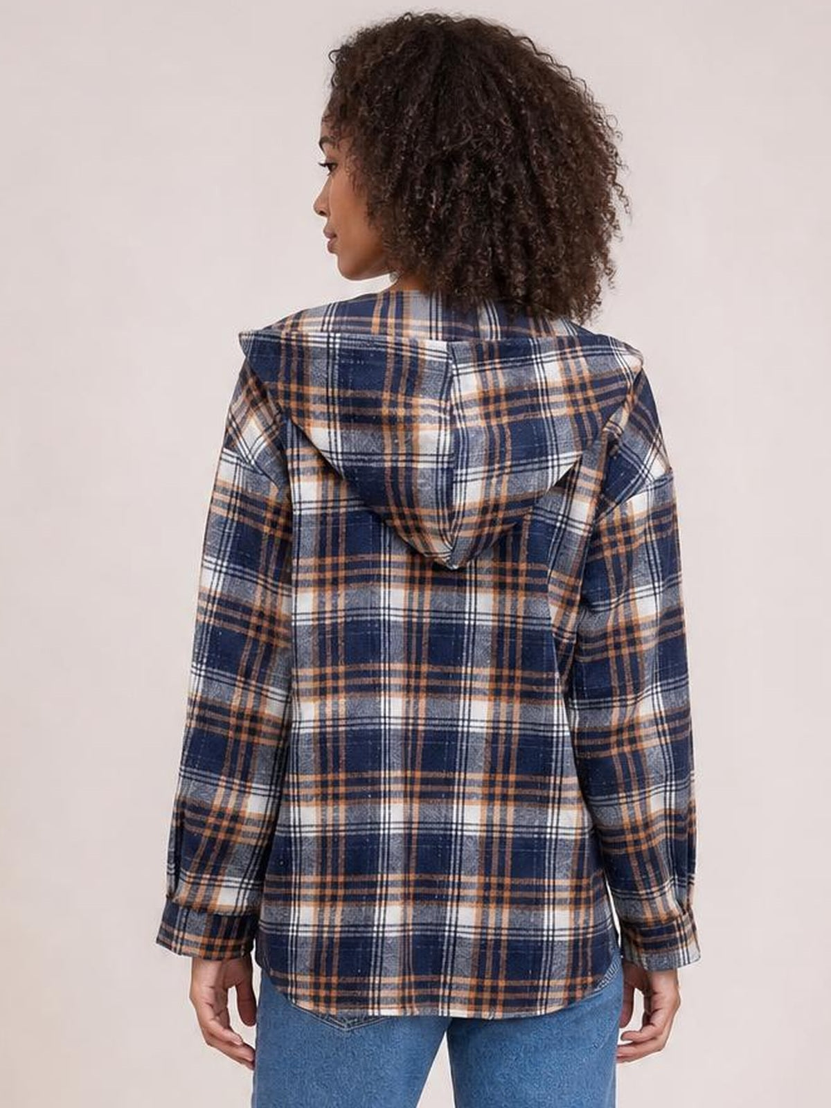 Back view of a model wearing a navy, tan, and white plaid long-sleeve hooded jacket with a straight silhouette, button placket, cuffs, and curved hem.