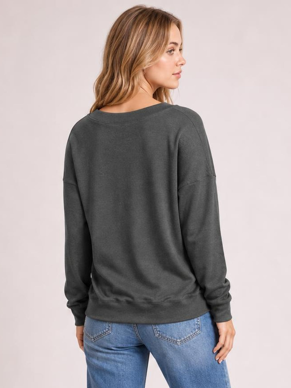 Model shown from behind wearing a charcoal dropped-shoulder blouse with long sleeves, relaxed silhouette, ribbed cuffs, and a ribbed hem.