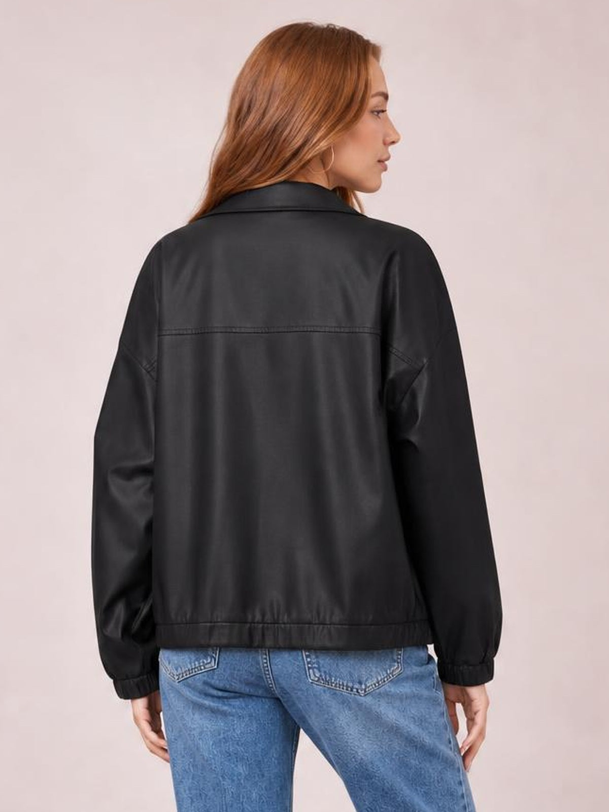 Model shown from behind wearing a black zip-up dropped-shoulder jacket with an oversized silhouette, collared neckline, seam detailing, and elastic cuffs and hem.