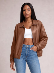 Model wears a brown zip-up dropped shoulder jacket with a collared design, relaxed silhouette, ribbed cuffs and hem, and visible pockets.