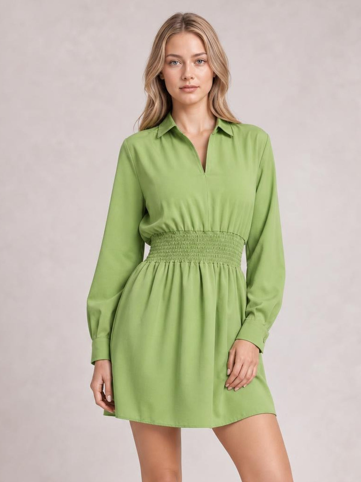 Model wears a lime green long-sleeve mini dress with a Johnny collar, V-neck opening, smocked waist, relaxed silhouette, and straight hem.