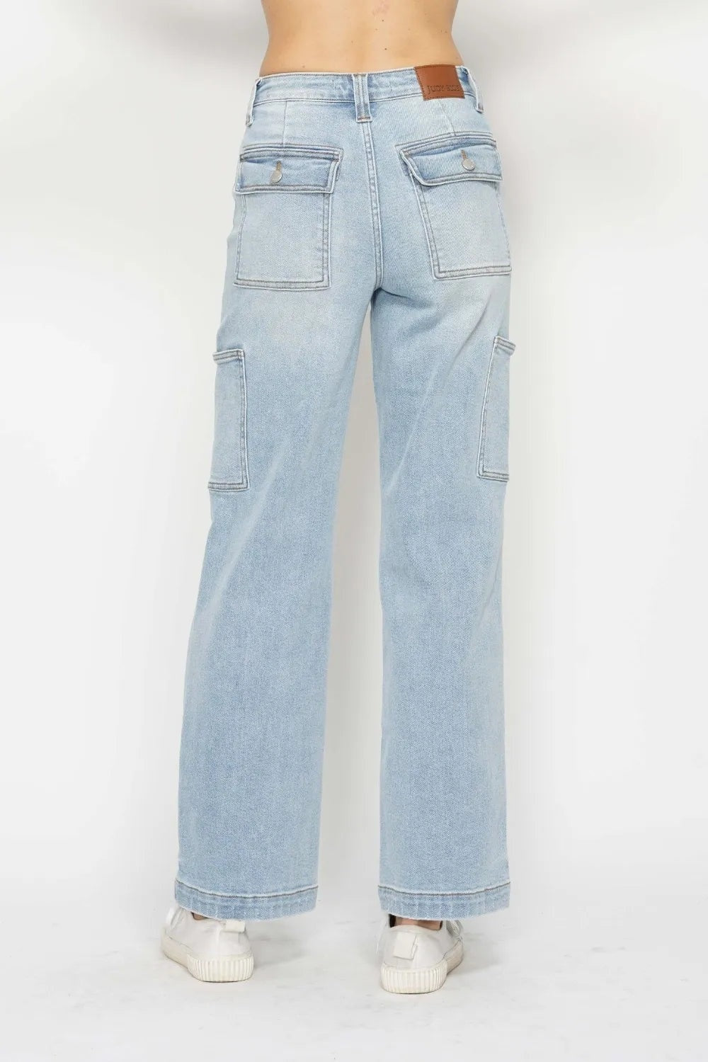 Model shown from behind wearing light-wash high waist straight cargo jeans with multiple flap pockets, belt loops, and a relaxed straight-leg silhouette.