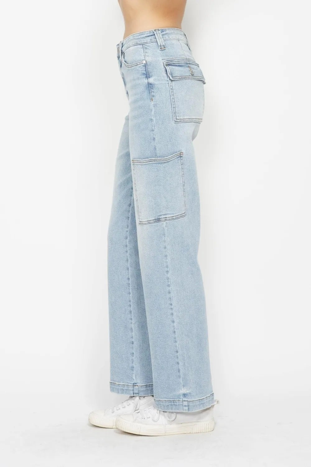 Model in profile wearing light-wash high waist straight cargo jeans with multiple flap pockets, belt loops, and a relaxed full-length silhouette.