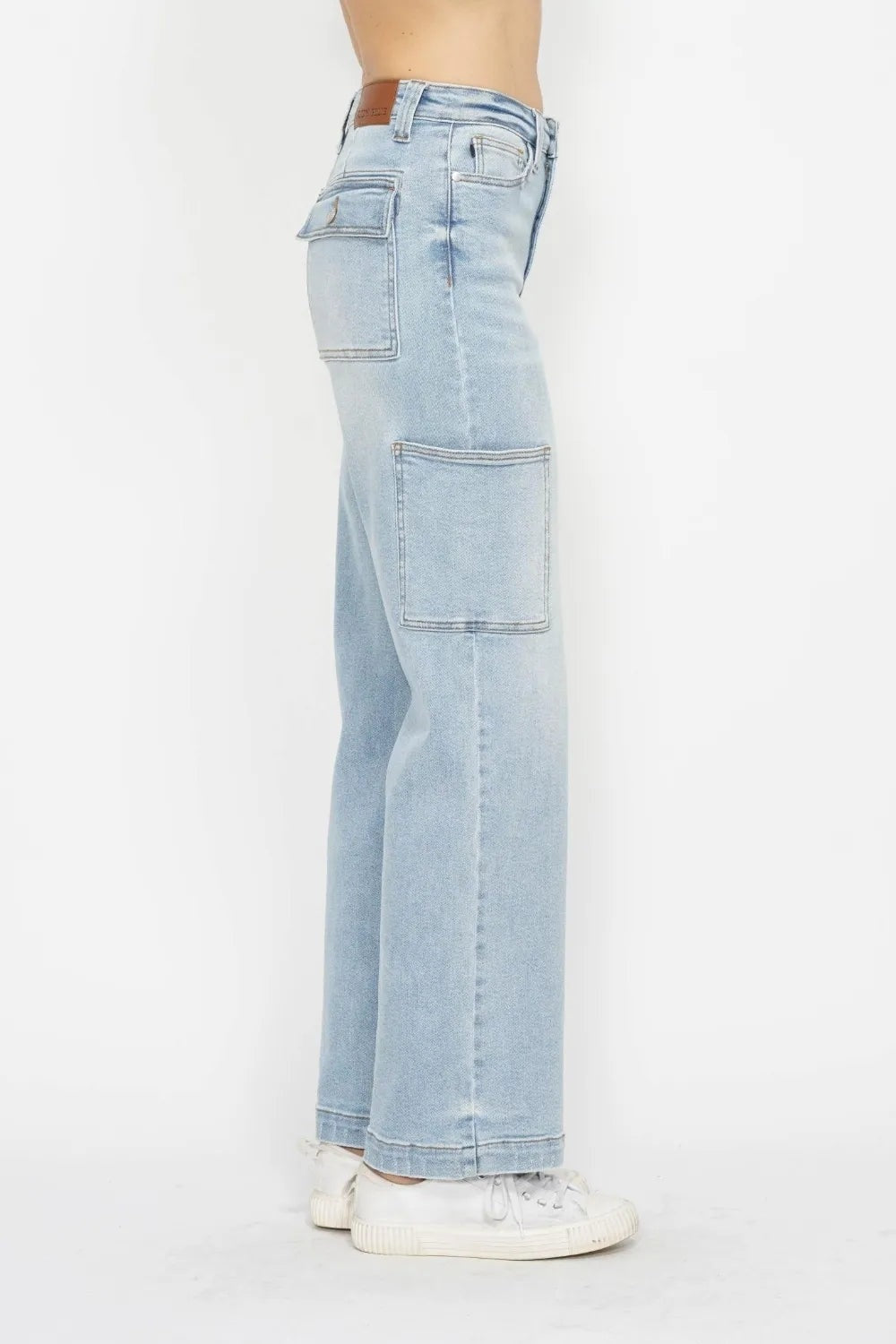 Side view of a model wearing light-wash JuBlue high waist straight cargo jeans with belt loops, front and flap pockets, large thigh pockets, and a relaxed straight-leg silhouette.