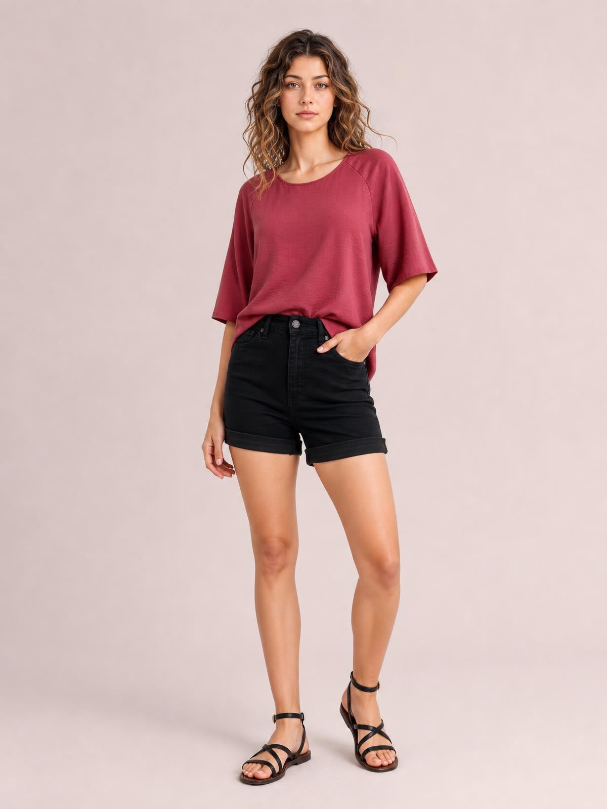 Model poses in black high-waist tummy control denim shorts with cuffed hems, a classic five-pocket construction, and a relaxed straight-leg silhouette.