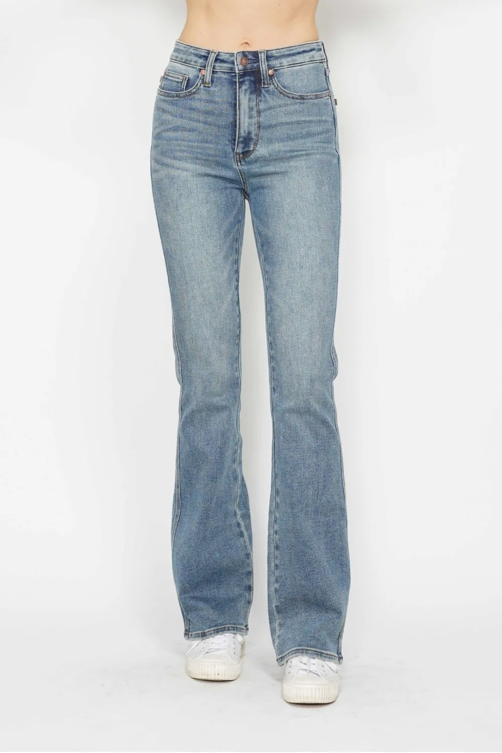 Model stands wearing light-wash tummy control jeans with a high-rise waist, belt loops, zip fly, front pockets, and a relaxed bootcut silhouette.