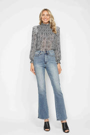 Model stands in light-wash tummy control jeans with a high-rise waistband, front pockets, belt loops, button fly, and a relaxed bootcut silhouette.
