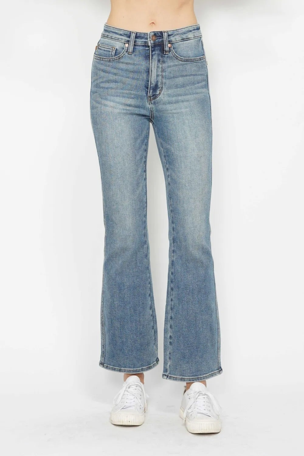 Model stands facing forward in light-wash tummy control jeans with a high rise, five-pocket construction, button fly, and relaxed bootcut legs.