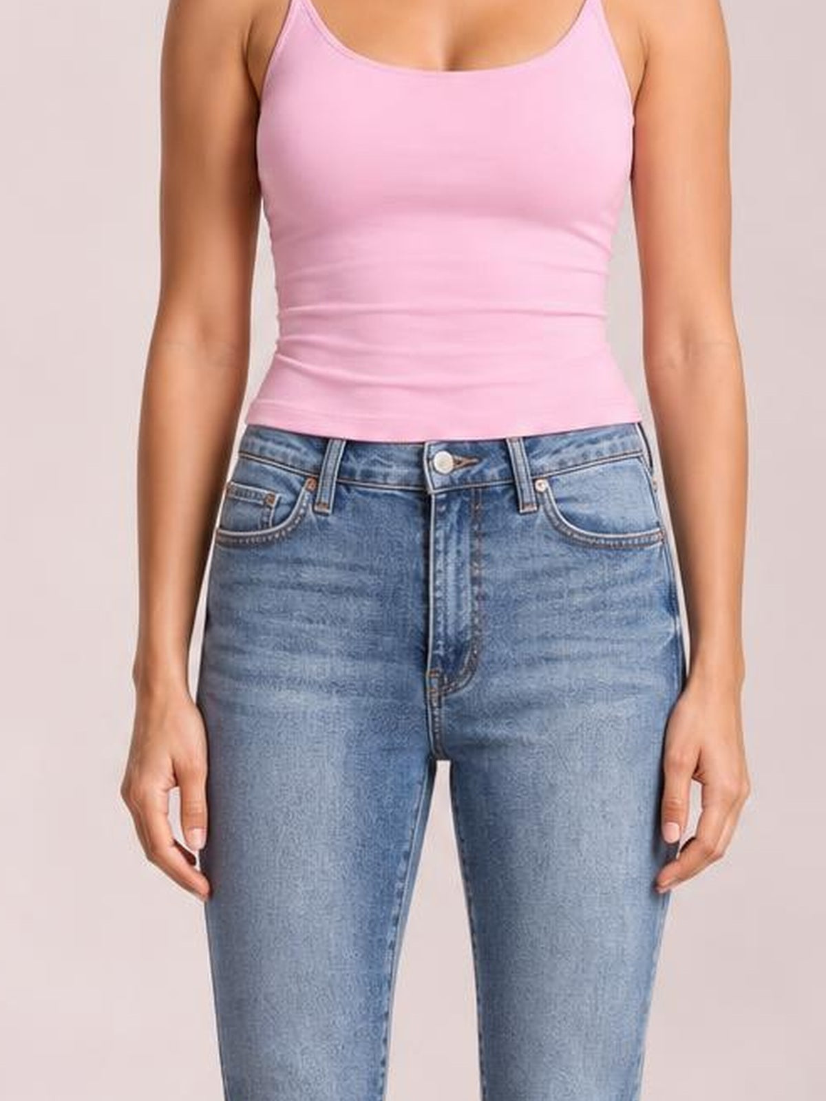 Model stands facing forward in high-rise JuBlue tummy control contrast-wash skinny jeans with a blue faded finish, zip fly, belt loops, and front pockets.