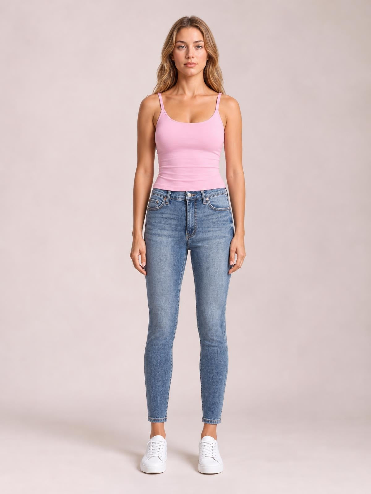 Model standing front-facing in light blue high-rise tummy control contrast-wash skinny jeans with pockets, belt loops, button fly, and tapered ankle-length legs.