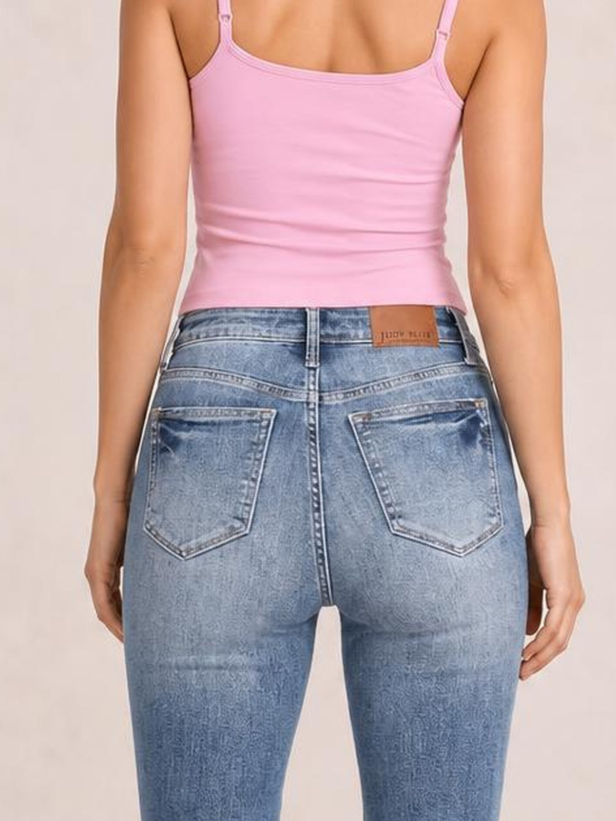 Model shown from behind wearing light blue high-rise tummy control skinny jeans with contrast wash, belt loops, back pockets, and fitted stretch denim.
