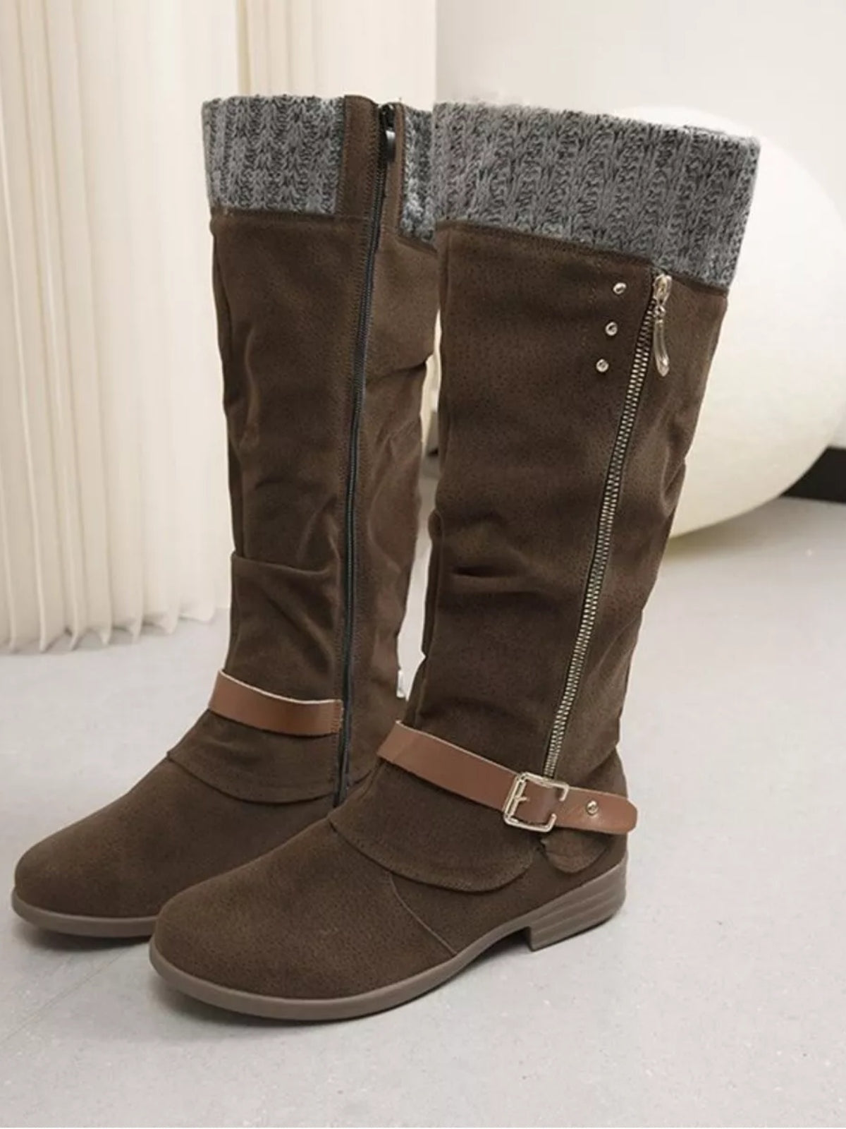 Brown suede knee-high slouch boots with gray knit cuffs, low heels, side zippers, and buckle ankle straps.