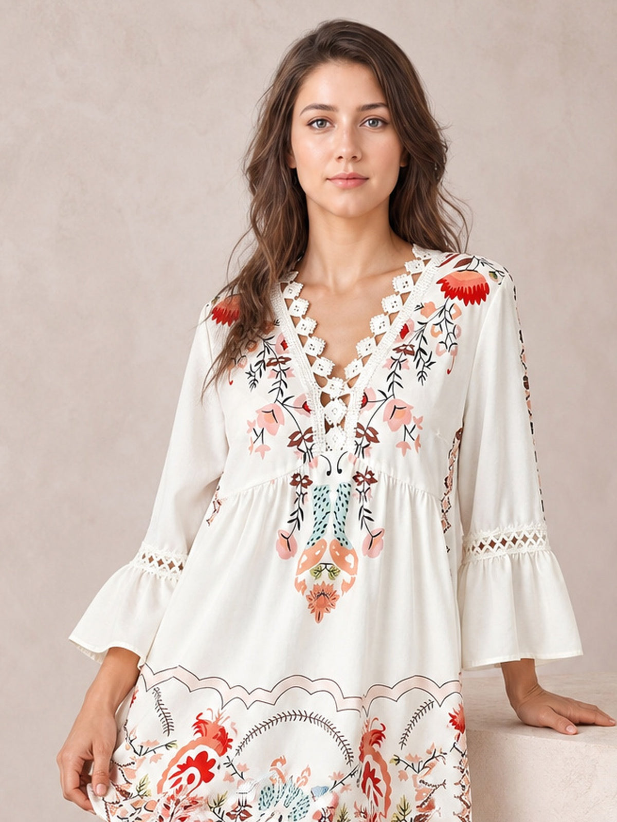 A model wears a white floral printed dress with lace-trimmed V-neckline, gathered waist, softly flared silhouette, and three-quarter bell sleeves.