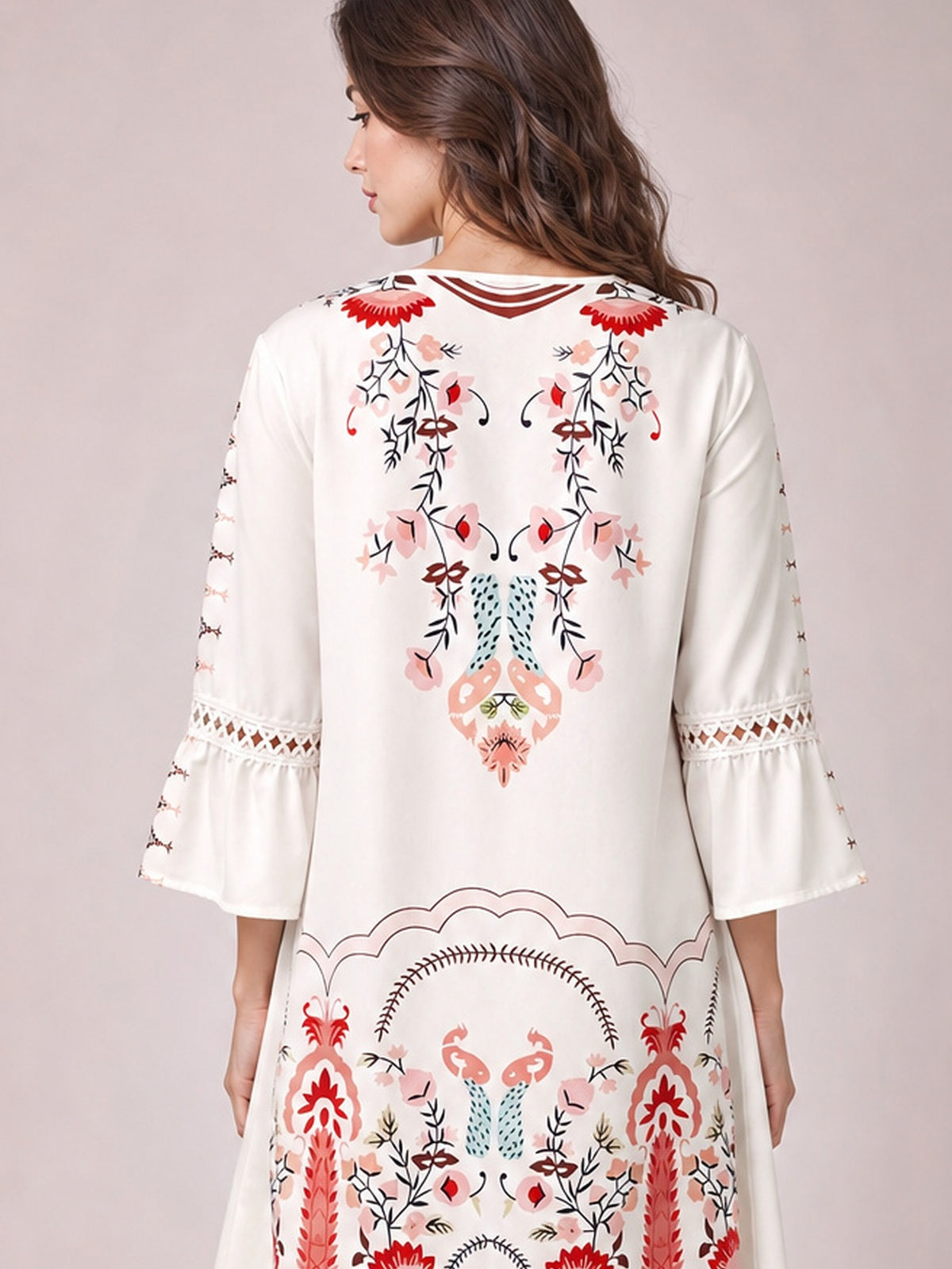 Model shown from behind wearing a white printed dress with floral motifs, three-quarter bell sleeves, lace sleeve bands, and a softly flared silhouette.