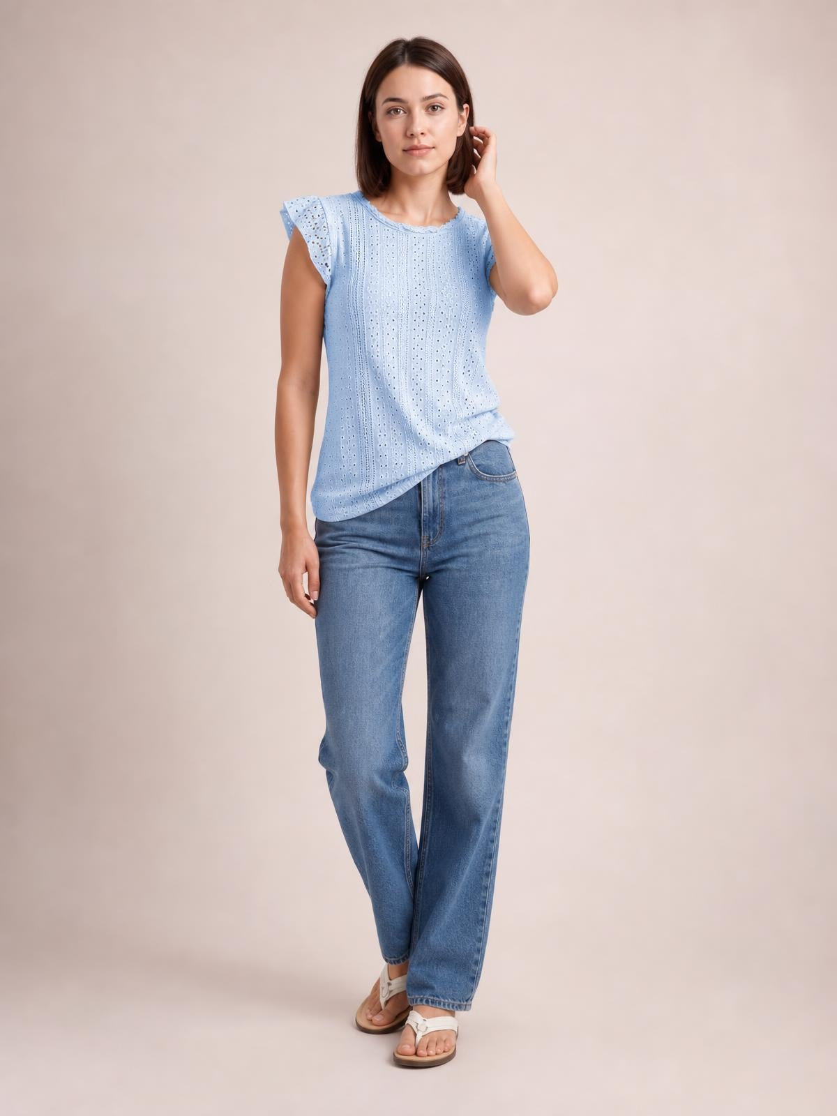Model poses in a light blue round-neck cap-sleeve top with eyelet lace detail, vertical openwork texture, and a relaxed straight silhouette.