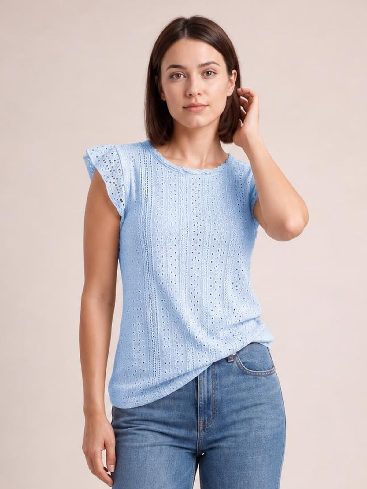 Model poses in a light blue round neck cap sleeve top with vertical eyelet lace detail, a relaxed silhouette, and a gently curved hem.