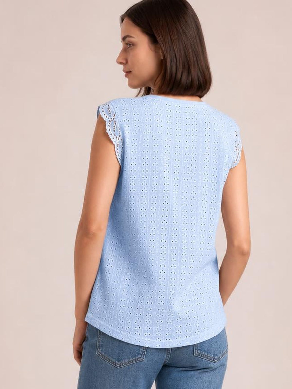Model shown from the back wears a light blue round-neck cap-sleeve top with eyelet fabric, lace-trimmed sleeves, and a relaxed curved-hem silhouette.