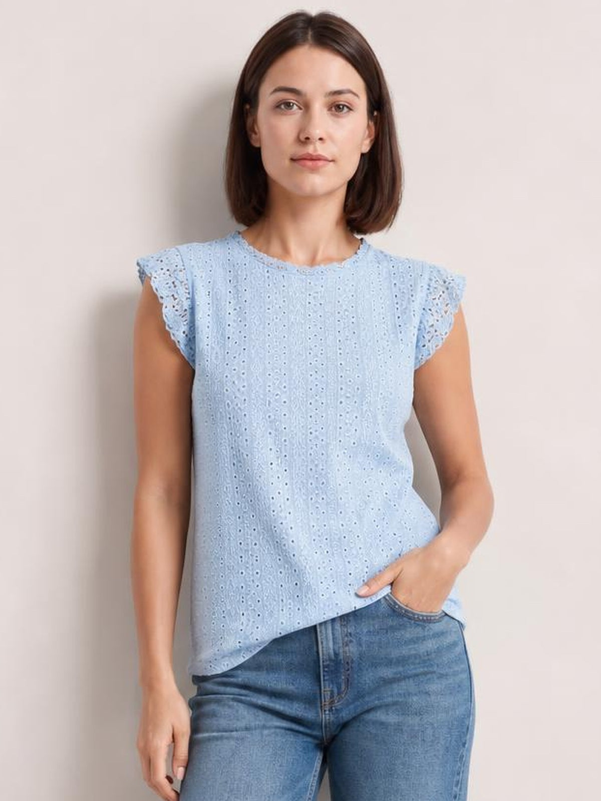 Model wears a light blue lace detail round neck top with eyelet fabric, ruffled cap sleeves, a relaxed straight silhouette, and a gently curved hem.