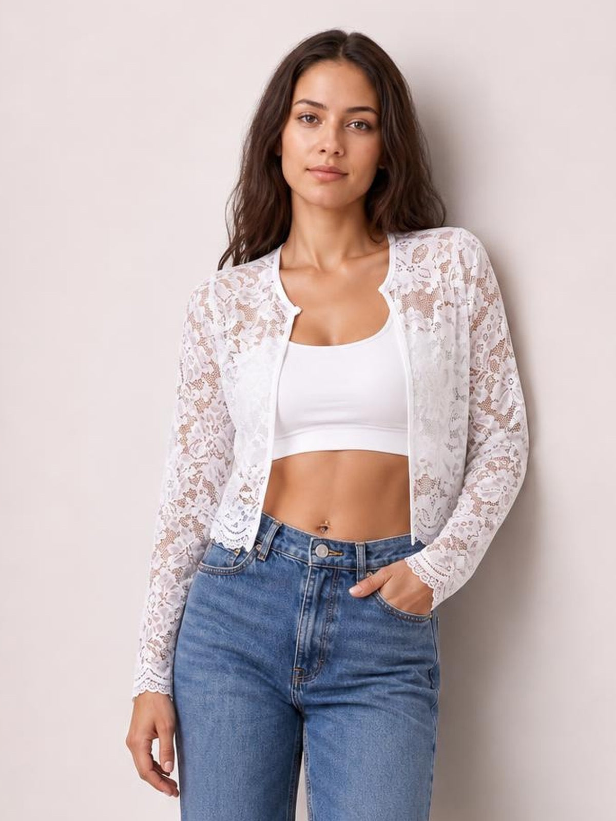 Model wearing a white lace open front long sleeve jacket with a sheer floral pattern, scalloped cuffs, and a fitted cropped silhouette.
