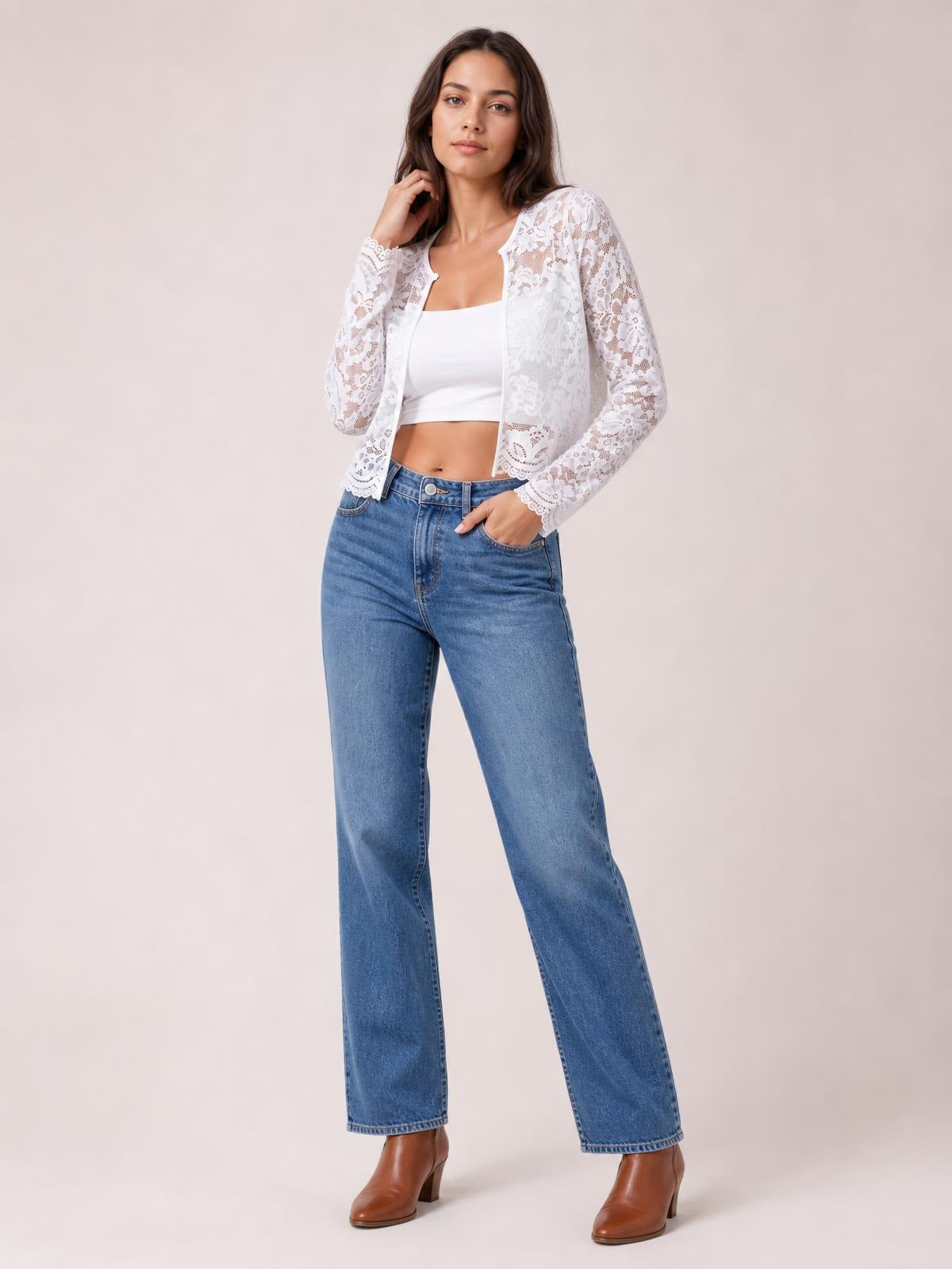 Model poses in a white lace open-front long-sleeve jacket with a relaxed cropped silhouette, scalloped edges, and floral openwork over a white top.