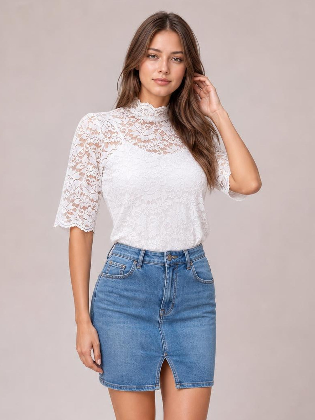 A model wears a white lace top with a mock neck, short puff sleeves, scalloped edges, and a regular silhouette while touching her hair.