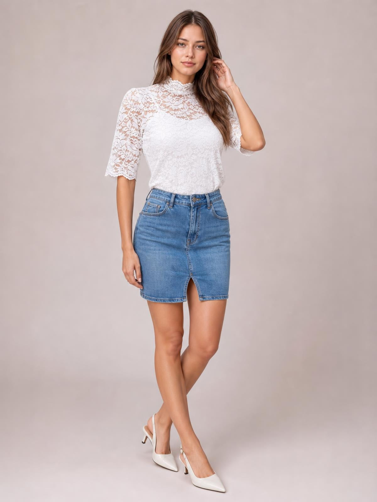 Model wears a white lace scalloped short puff sleeve top with a mock neck and regular fit, standing with crossed legs and one hand touching her hair.
