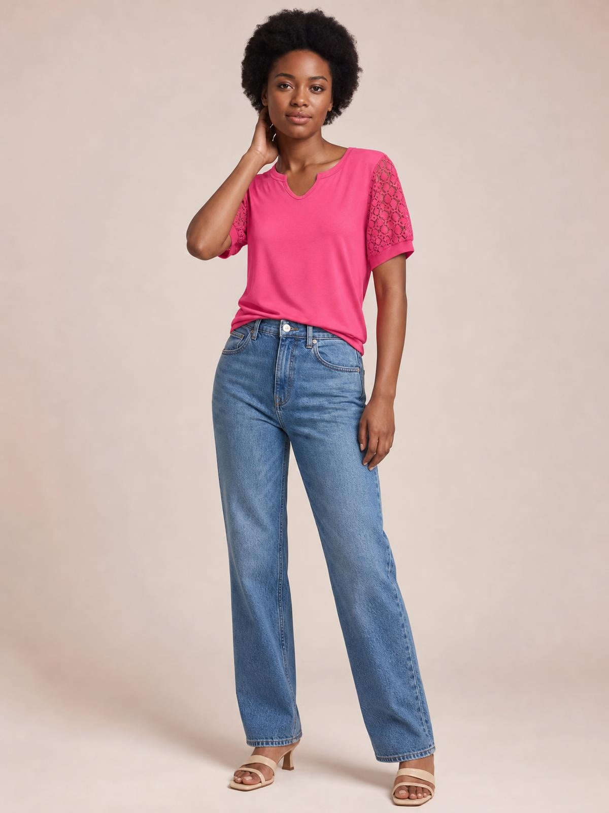 A model poses in a bright pink lace short sleeve T-shirt with semi-sheer openwork sleeves, a notched neckline, and a relaxed silhouette.