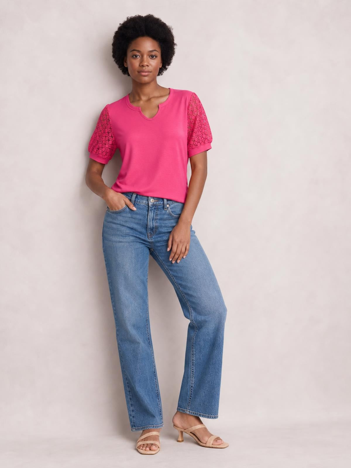 Model wears a bright pink lace short sleeve T-shirt with semi-sheer openwork sleeves, a relaxed silhouette, and a notched round neckline.