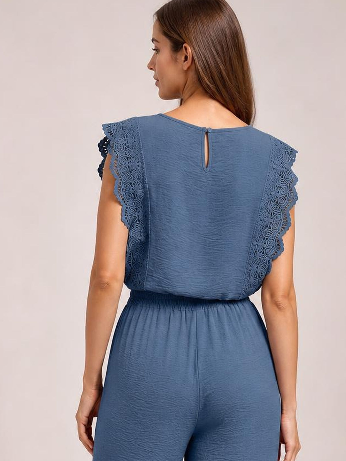 Back view of a model in a blue lace-trim top and pants set, featuring flutter sleeves, a buttoned keyhole neckline, and an elastic waist.