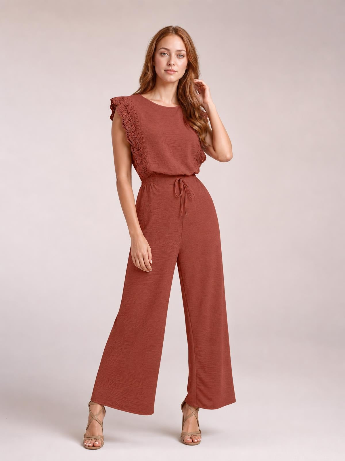 A model poses in a rust lace-trim round-neck top and matching pants set, featuring flutter sleeves, a tied waist, and a wide-leg silhouette.