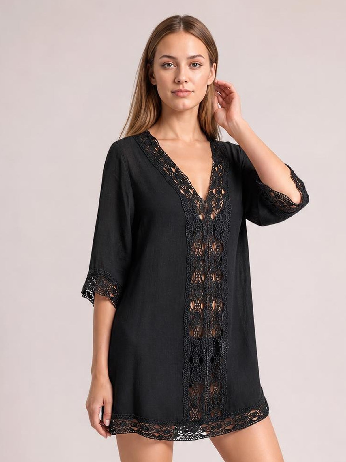 Model poses in a black V-neck cover-up with a loose silhouette, three-quarter sleeves, and delicate lace trim along the neckline, cuffs, center, and hem.