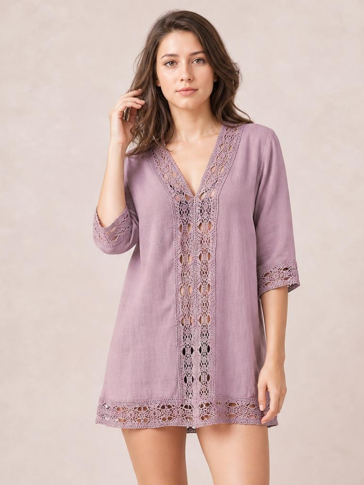 A model poses in a mauve V-neck cover-up with delicate lace trim, three-quarter sleeves, a relaxed tunic silhouette, and lace detailing at the hem.