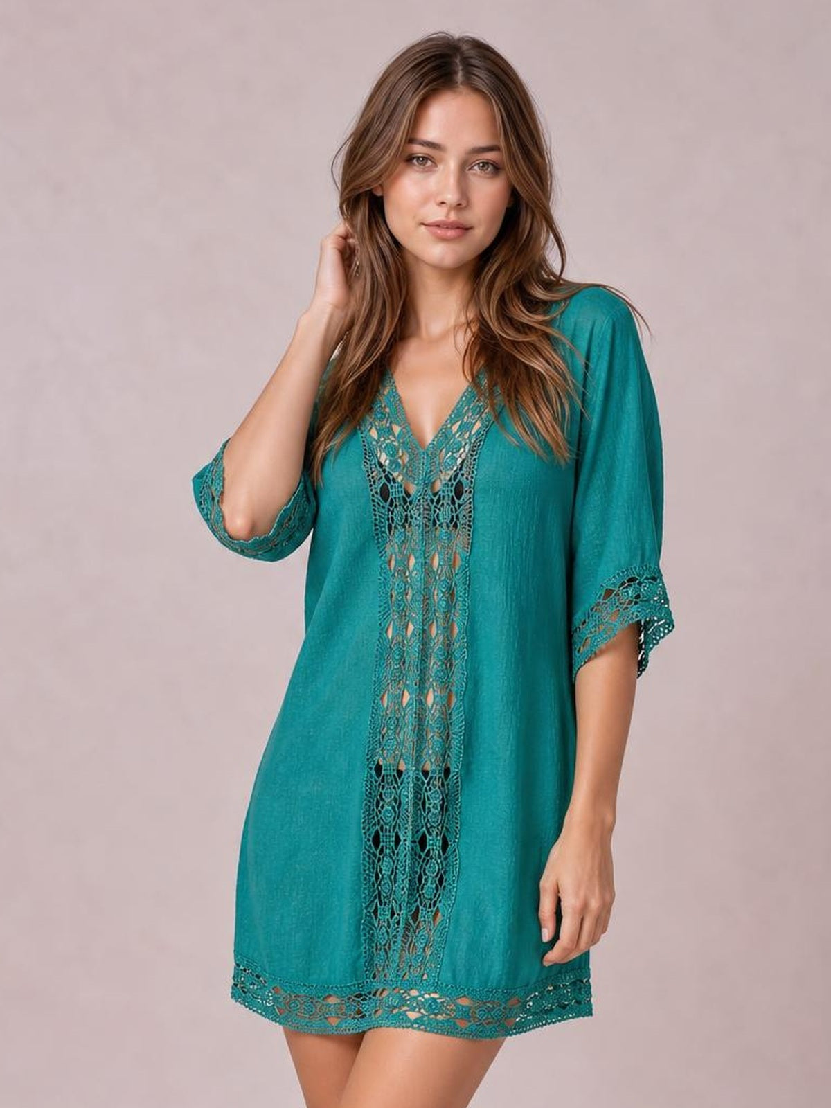 Model poses in a teal lace trim V-neck cover-up with a relaxed tunic silhouette, three-quarter sleeves, and intricate lace panels at the front, cuffs, and hem.