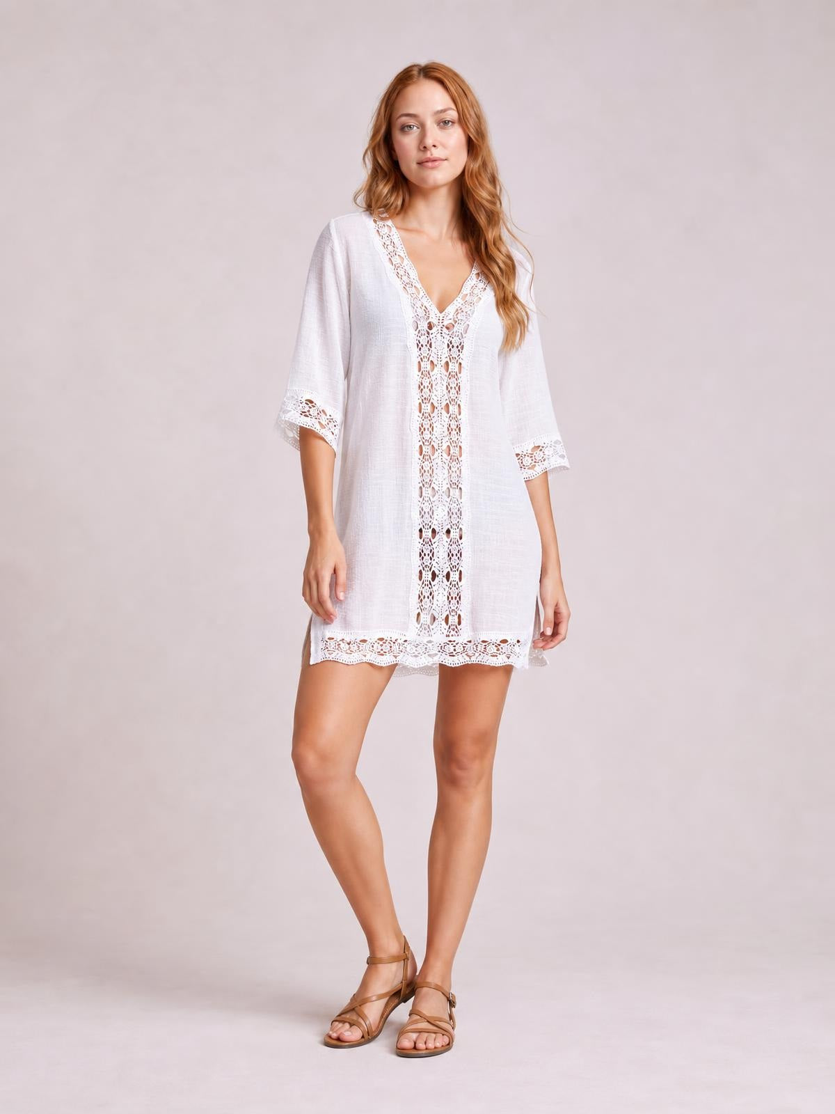 A model poses in a white lace-trim V-neck cover-up with a relaxed straight silhouette, three-quarter sleeves, and delicate lace panels at the front, cuffs, and hem.