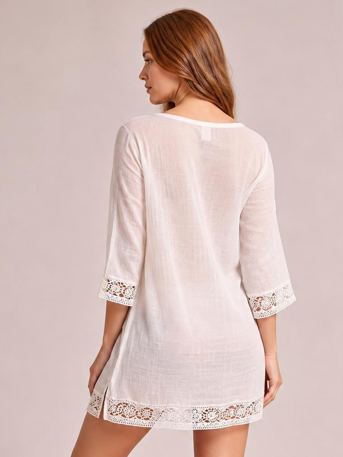 Model shown from behind wears a white lace-trim cover-up with a relaxed silhouette, three-quarter sleeves, and delicate lace cuffs and hem.