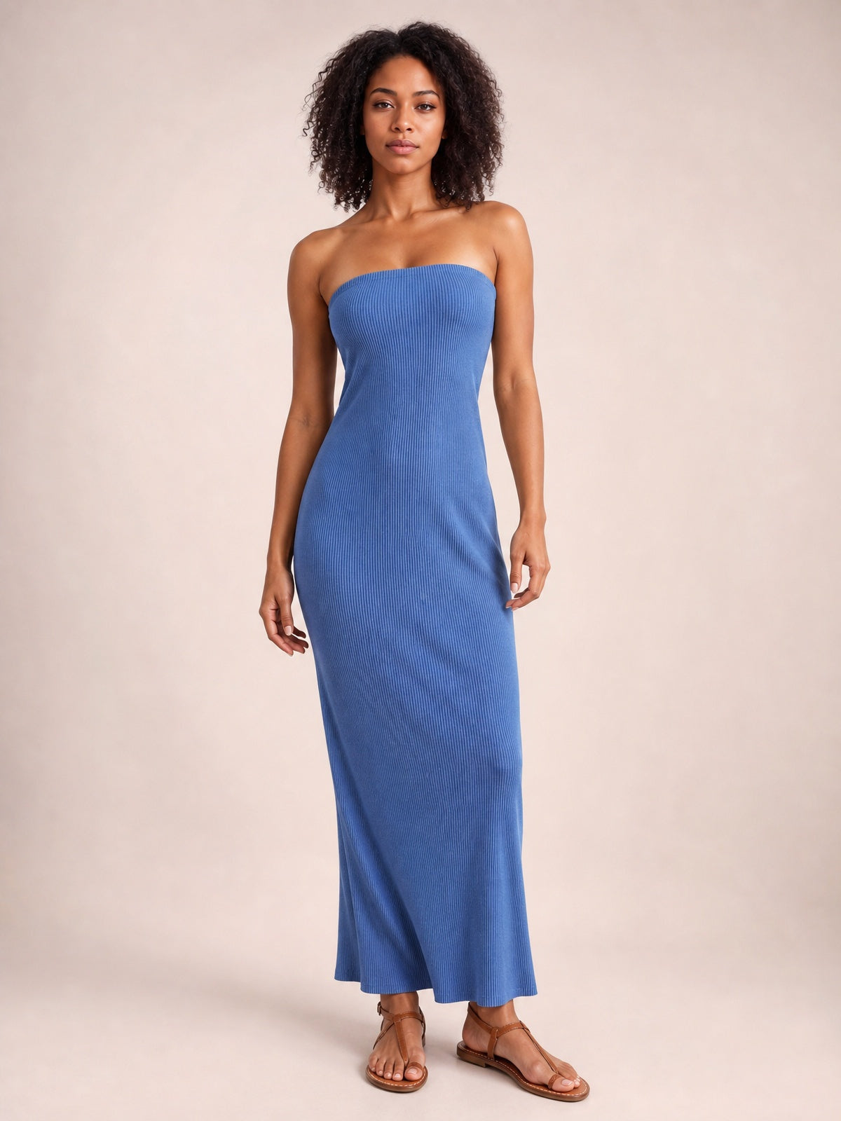Model stands in a blue ribbed Lace-Up Back Tube Maxi Dress with a strapless neckline, fitted column silhouette, and gently flared ankle-length hem.