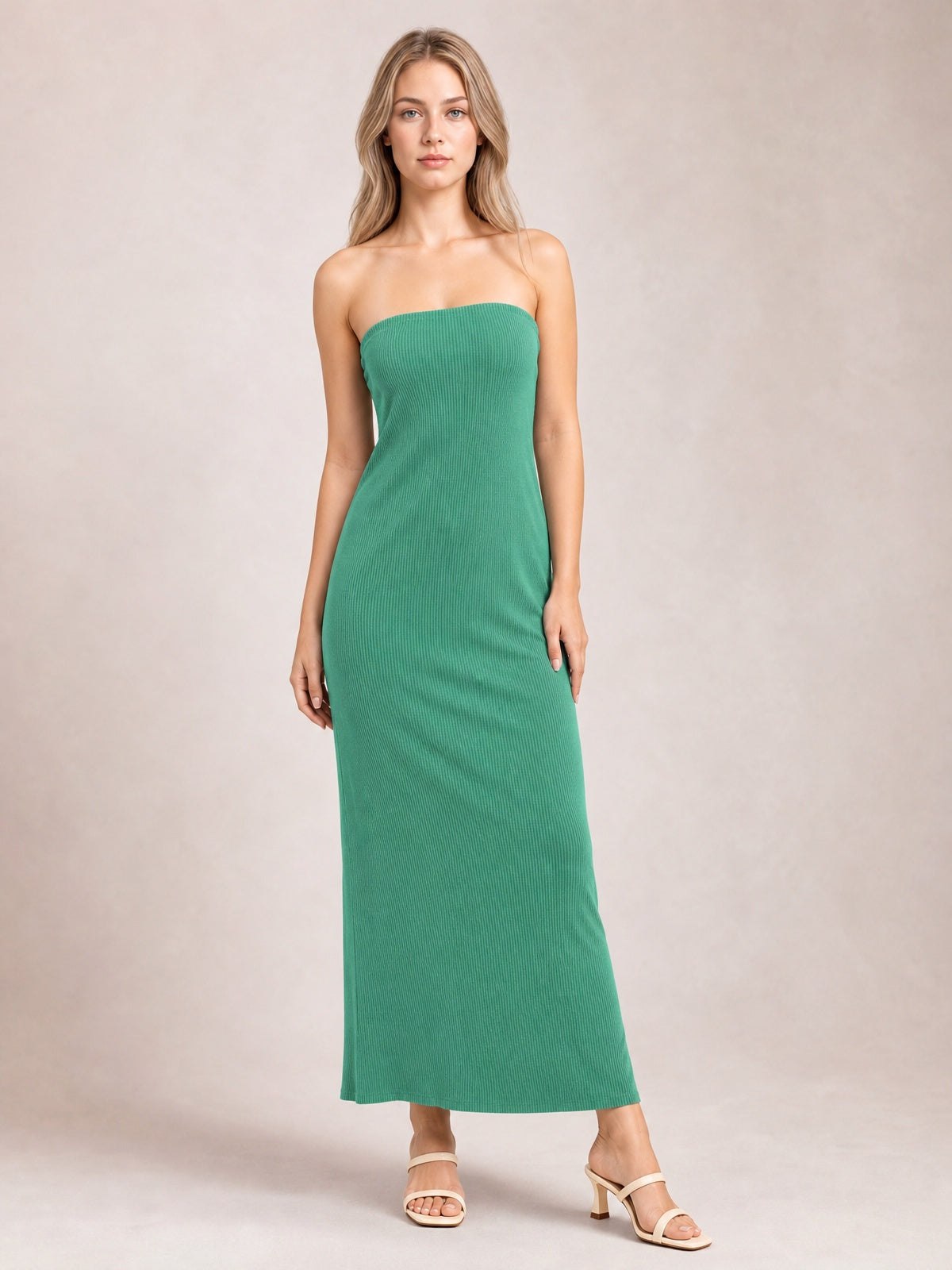 Model poses in a green strapless tube maxi dress with a body-skimming column silhouette, subtle ribbed texture, and softly fluid full-length hem.