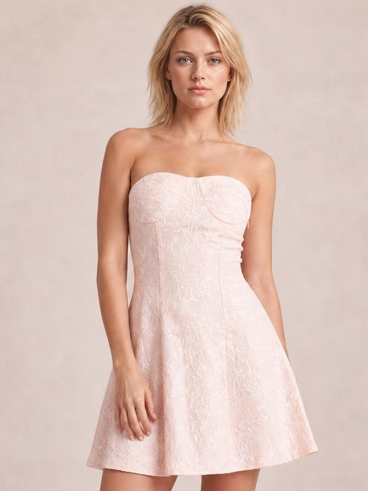 Model wearing a pale pink lace-up jacquard tube mini dress with a strapless neckline, fitted bodice, seam detailing, and flared A-line skirt.