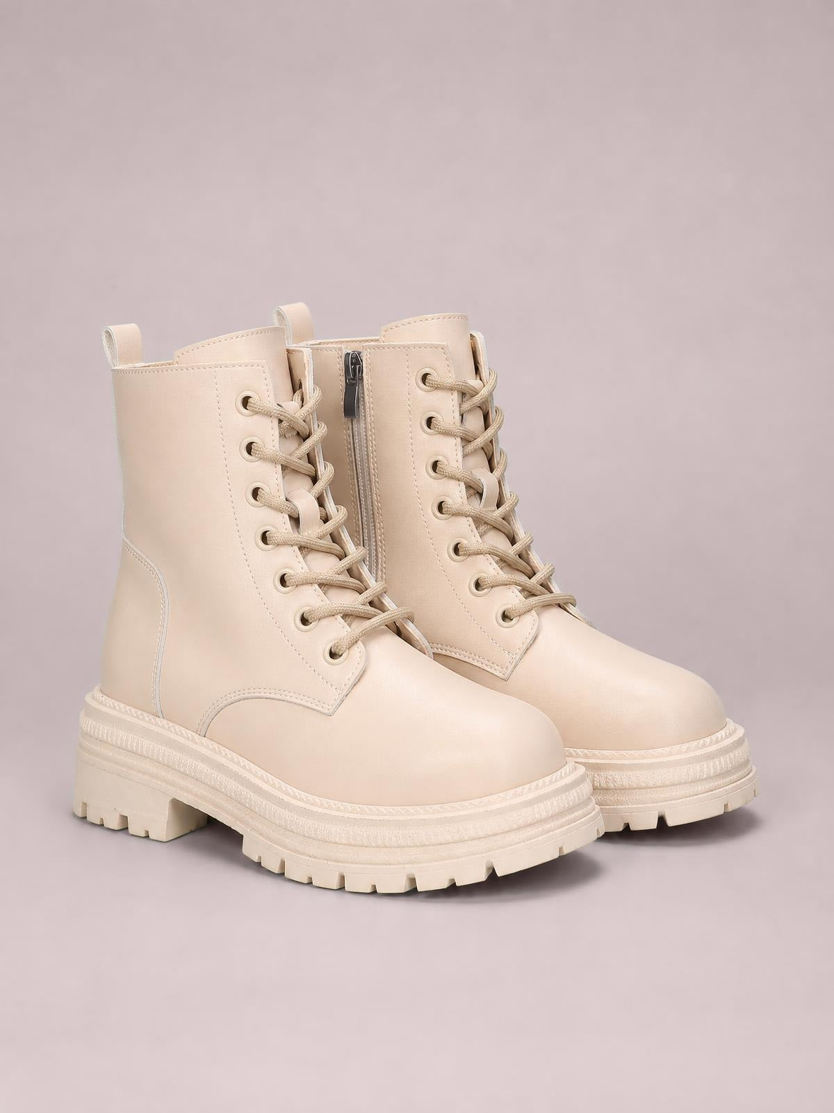 Cream PU leather lace-up platform boots with low heels, round toes, rugged rubber soles, stitched panels, and visible side zips.