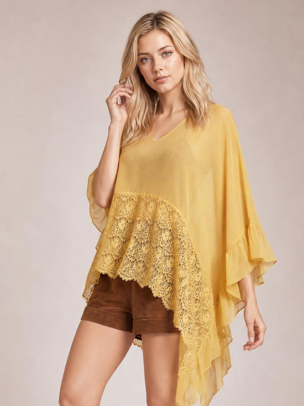 A model poses in a mustard-yellow lace V-neck cover-up with a flowing silhouette, lace hem panel, and layered ruffle sleeves.