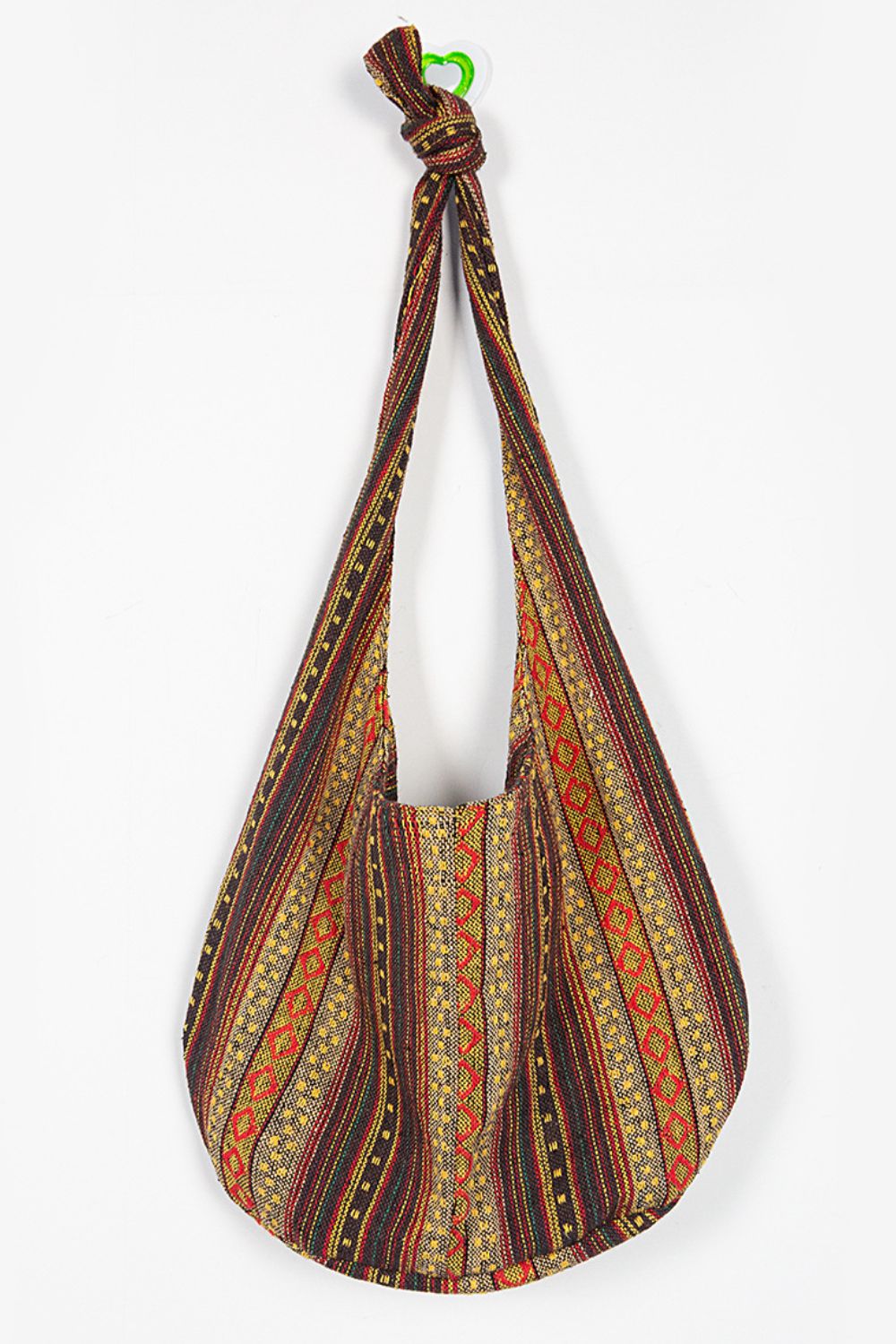 Large canvas crossbody bag with a softly rounded, slouchy silhouette, elongated knotted strap, and bold multicolor striped geometric weave.