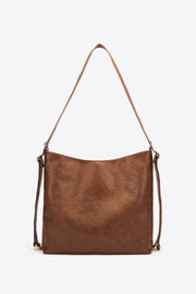 Large chocolate brown PU leather crossbody bag with a softly structured rectangular silhouette, gently curved top, long adjustable strap, and side buckle details.