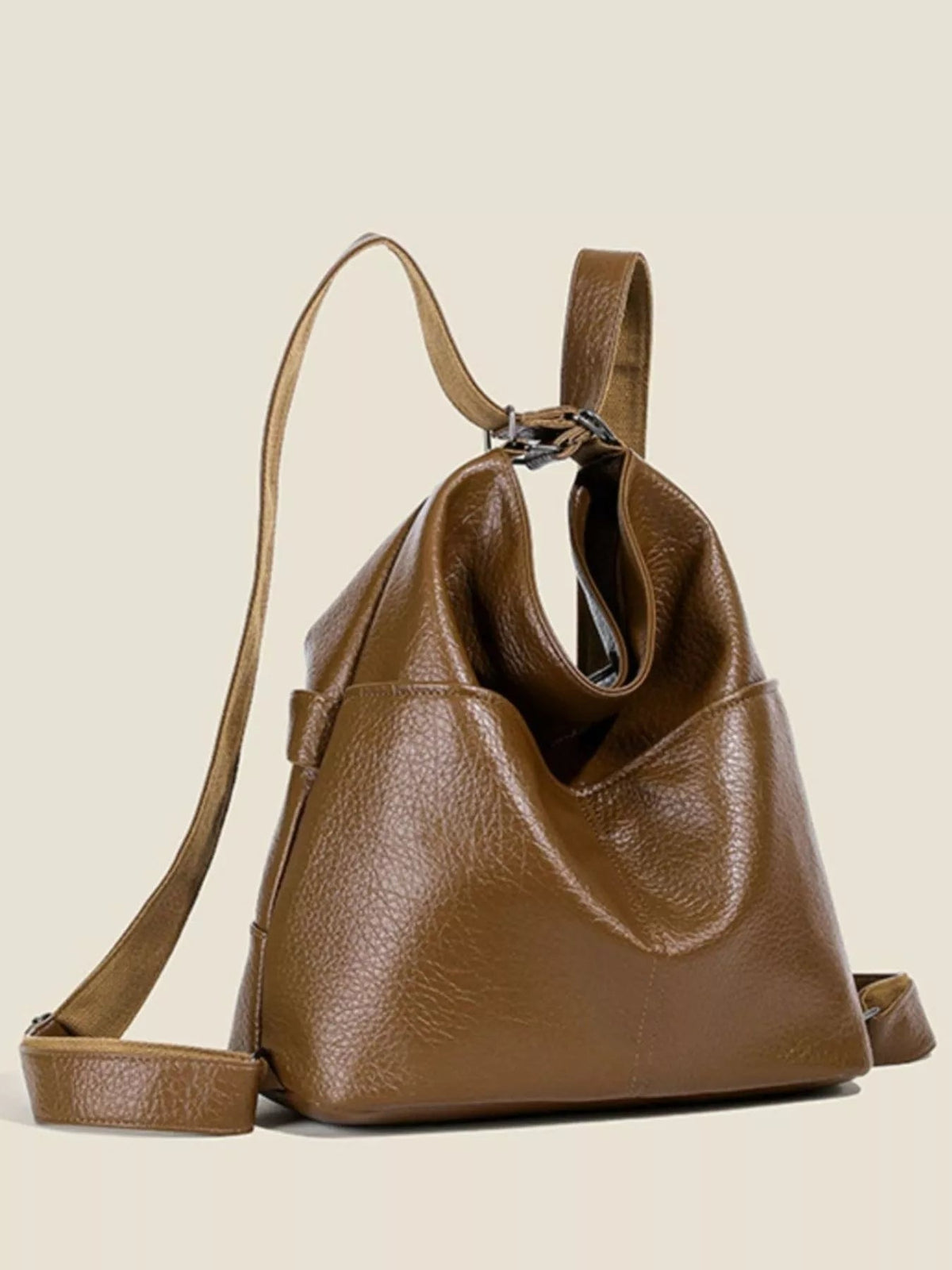 Medium brown PU leather convertible shoulder bag with a structured slouchy silhouette, wide top opening, short handles, and a long adjustable strap.