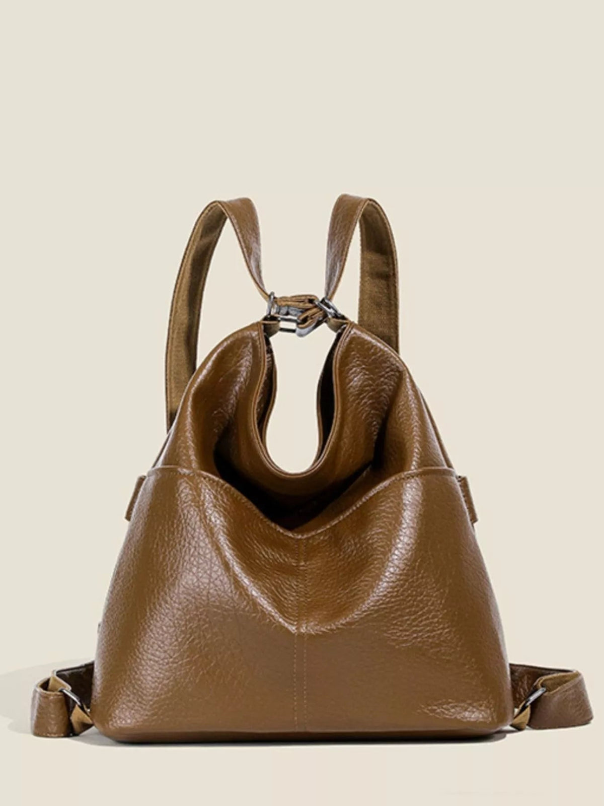 Brown medium PU leather convertible shoulder bag with a slouchy silhouette, dual top straps, side hardware, folded panels, and a front center seam.