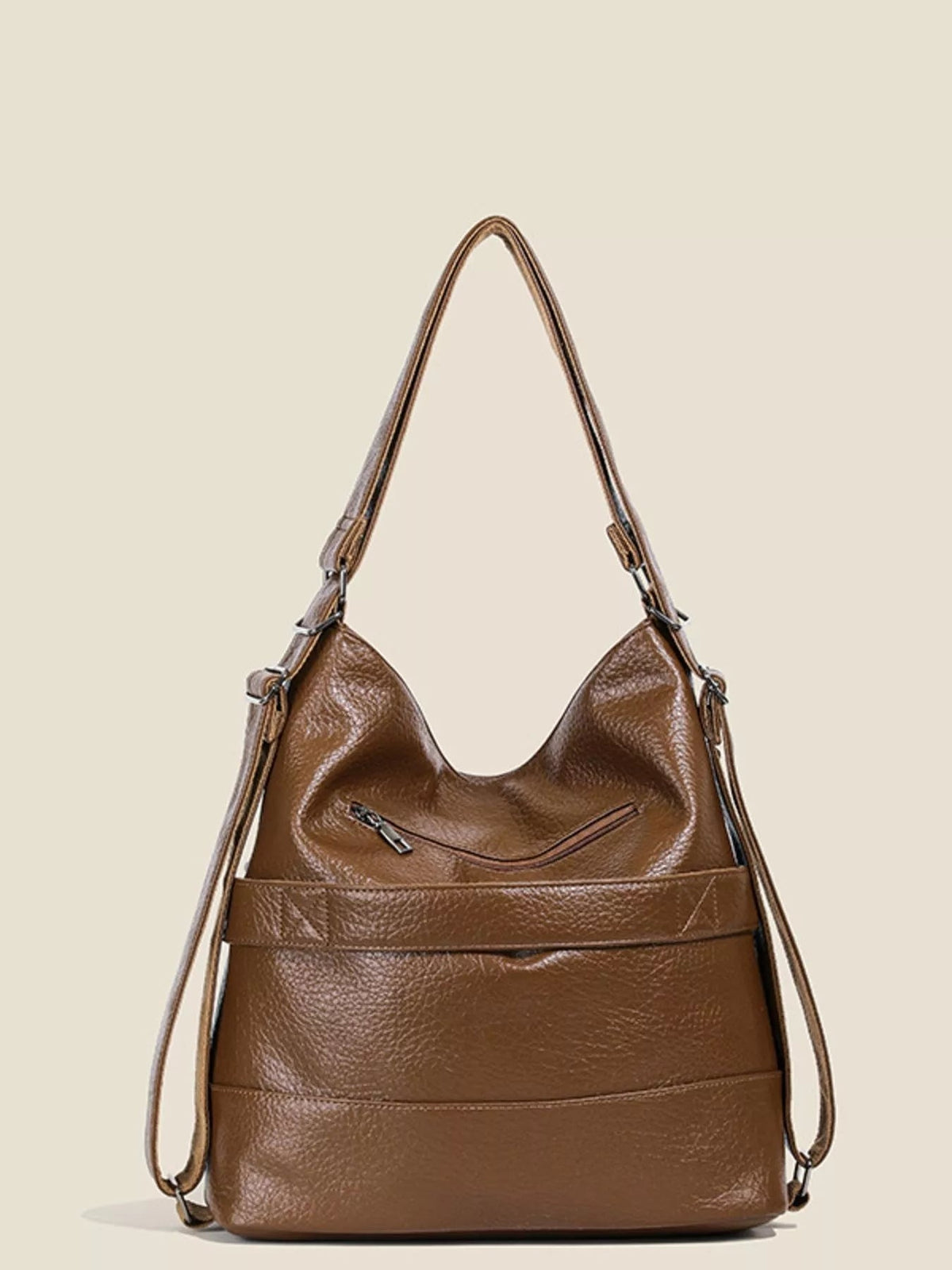 Medium brown PU leather convertible shoulder bag with a slouchy silhouette, dual adjustable straps, front zip pocket, and pebbled construction.