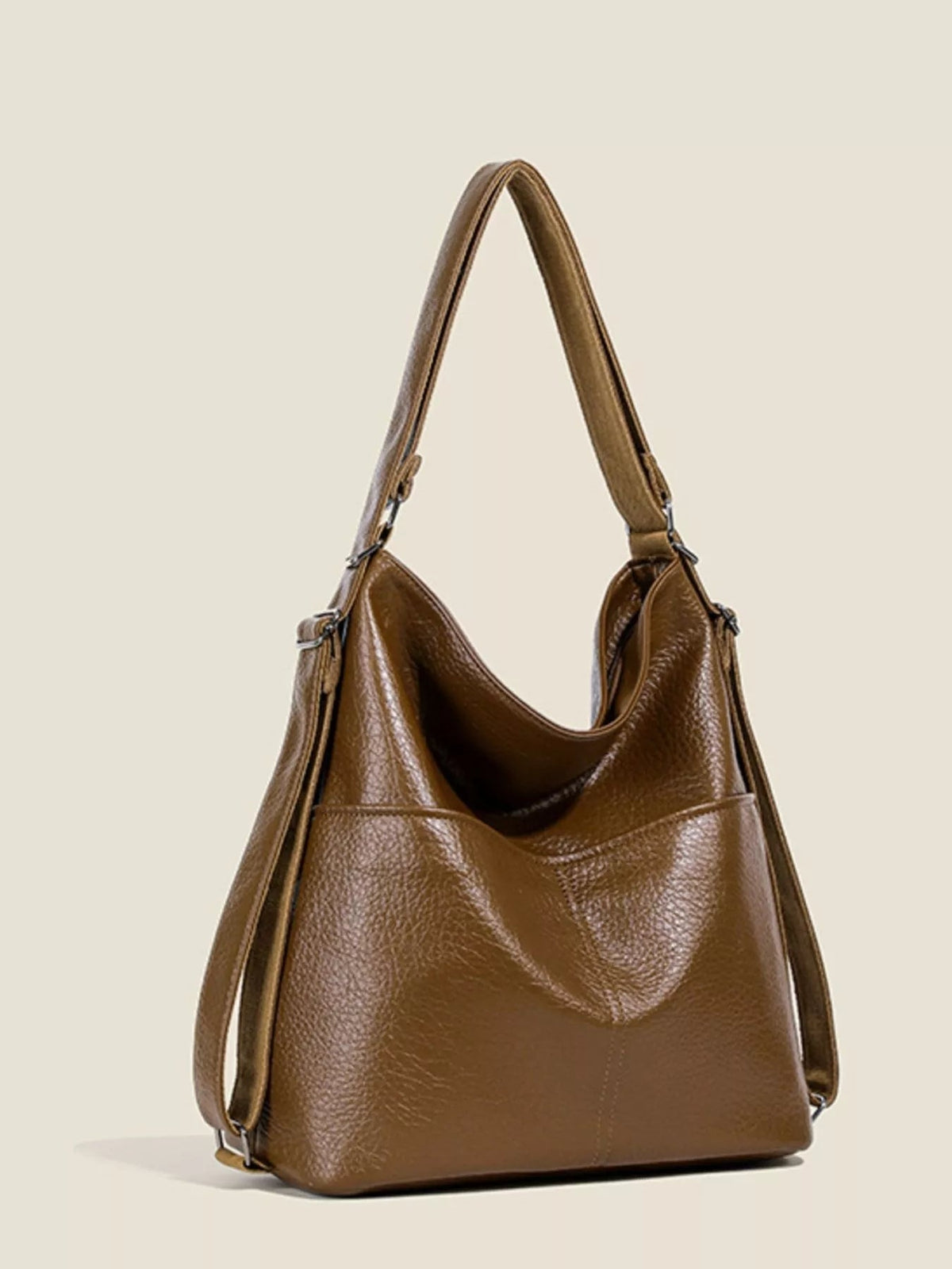 Medium brown PU leather convertible shoulder bag with a slouchy silhouette, wide adjustable strap, open top, and structured base.